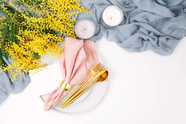 Festival Tablo ayarı. Tabak ve çatal bıçak takımı gri dekoratif Tekstil ve beyaz zemin üzerine sarı çiçekleri ile. Güzel aranjman.