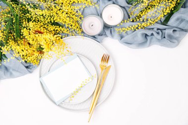 Festival Tablo ayarı. Tabak ve çatal bıçak takımı gri dekoratif Tekstil ve beyaz zemin üzerine sarı çiçekleri ile. Güzel aranjman.
