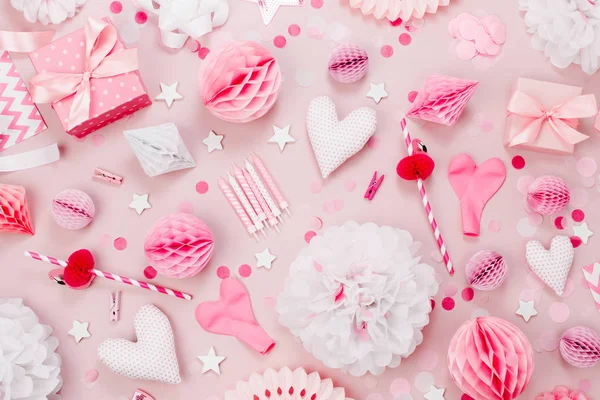 Pink and white Paper Decorations, pom-pom, candies, hearts, gifts, confetti for Baby party. Birthday concept.  Flat lay, top view