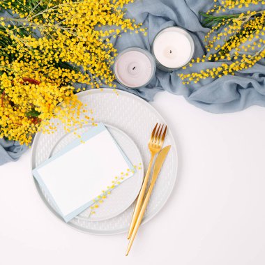 Festival Tablo ayarı. Tabak ve çatal bıçak takımı gri dekoratif Tekstil ve beyaz zemin üzerine sarı çiçekleri ile. Güzel aranjman.
