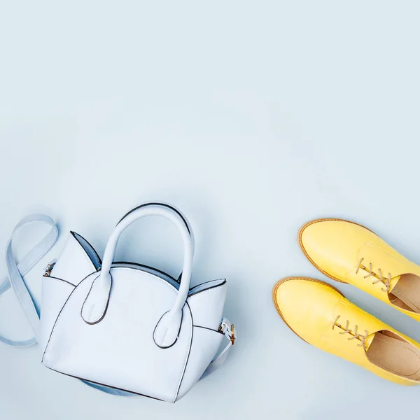 Lovely blue ladies bag, sunglasses and stylish yellow shoes. Spring fashion concept