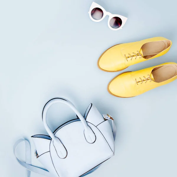 Lovely blue ladies bag, sunglasses and stylish yellow shoes. Spring fashion concept