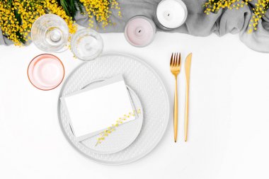 Festival tabak, çatal bıçak takımı, gri dekoratif Tekstil, Mimoza, cam ve beyaz arka plan üzerinde mum boş oyun kağıdı.