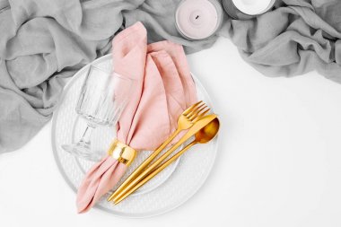 Festival tabak ve çatal bıçak takımı gri dekoratif Tekstil, pembe peçete ve beyaz zemin üzerine mum.