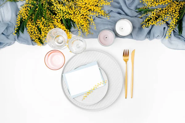 Festival tabak, çatal bıçak takımı, gri dekoratif Tekstil, Mimoza, cam ve beyaz arka plan üzerinde mum boş oyun kağıdı.