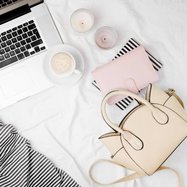 Moda blogger çalışma alanı, mumlar ve Notebook yatakta kahve bej çanta laptop.