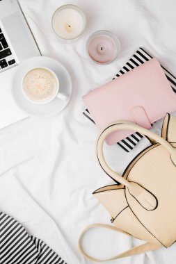 Moda blogger çalışma alanı, mumlar ve Notebook yatakta kahve bej çanta laptop.