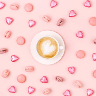 Candys ve soluk pembe bir arka plan üzerinde macaroons kahve fincanı. Düz yatıyordu, en iyi görünümü