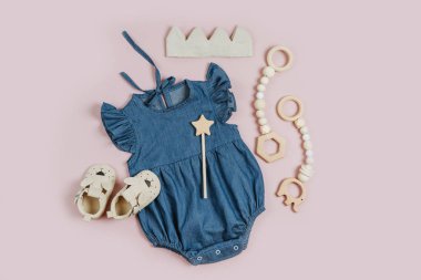 Cute set of baby clothes and accessories for girl on pink background. Blue romper with cotton crown and baby shoes. Fashion newborn bodysuit. Flat lay, top view
