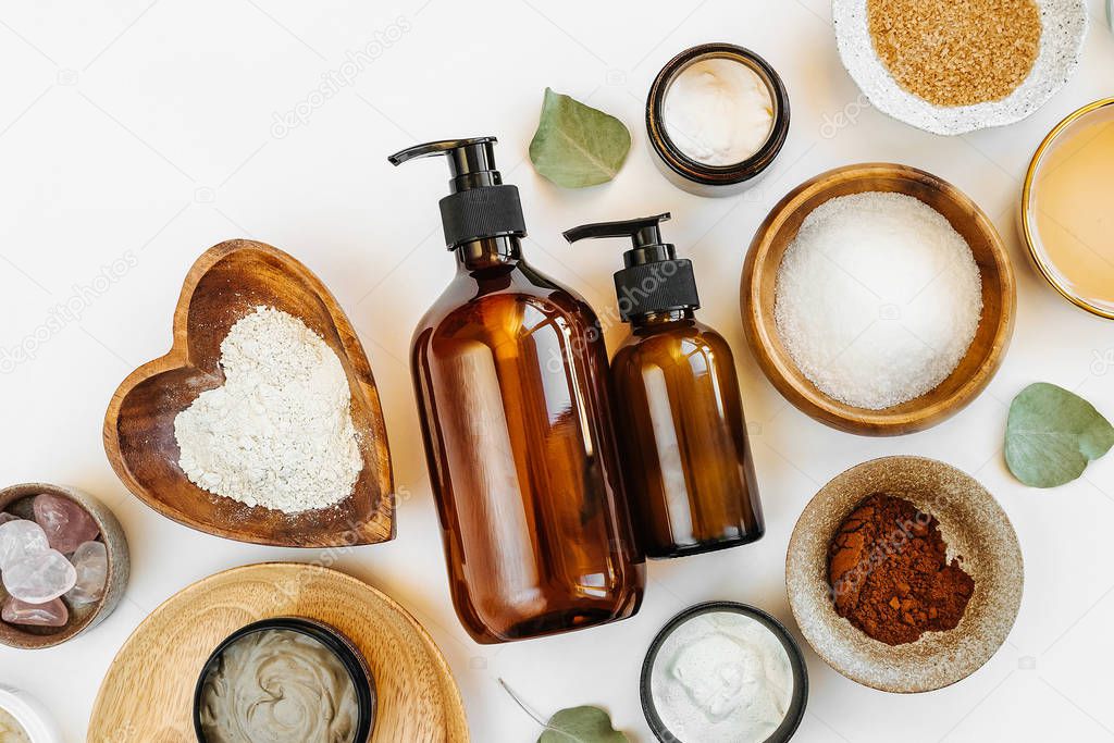 Beauty treatment ingredients for making homemade skin care cosmetic mask. Various bowl with clay, cream, essential oil and natural ingredients  on white table background. Organic spa cosmetic products