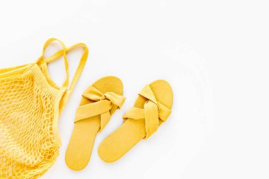Yellow slippers with eco bag. Flat lay, top view. Summer Vacation concept.