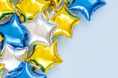 Gold and silver foil balloons of star shaped on blue background. Holiday and celebration concept. Birthday Day or party decoration. Metallic air balloons. Congratulation. Greeting card. 