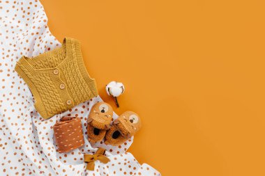 Sarı örgü şort, çoraplar ve muslin kundak battaniyeli şirin bebek terlikleri. Yeni doğan kıyafetleri ve aksesuarlar. Düz yatış, üst görünüm 