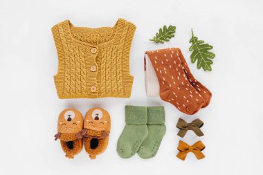 Sarı örgü şort, çoraplar ve şirin bebek terlikleri. Yeni doğan kıyafetleri ve aksesuarlar. Düz yatış, üst görünüm 