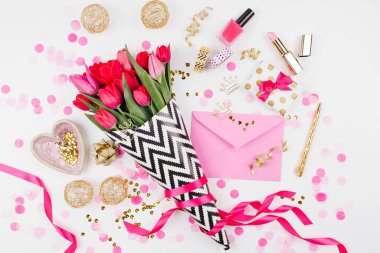 Pembe ve altın tarz Masası çiçekler ile. Siyah ve beyaz şık ambalaj kağıdı, hediyeler, kozmetik ve beyaz zemin üzerine konfeti ile kadın Aksesuarları Pembe Laleler