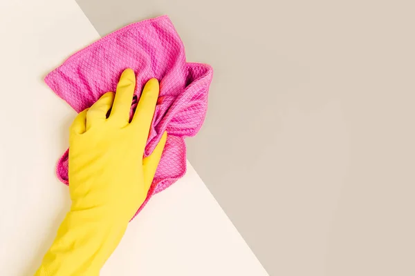 Female hands cleaning on pale yellow background. Cleaning or housekeeping concept background. Copy space. Flat lay, Top view.