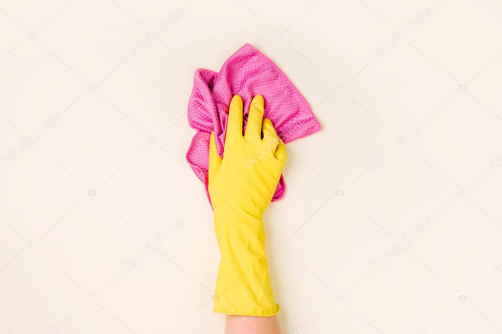  Female hands cleaning on pale yellow background. Cleaning or housekeeping concept background. Copy space. Flat lay, Top view.