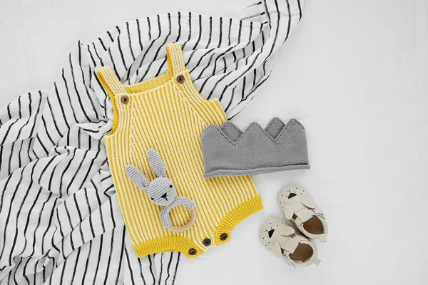 为新生儿在黑白毛毯上编织的黄色保险杠和带冠与玩具兔子聚醚 婴儿用品和配件 平躺在地上 俯瞰四周 — 图库照片