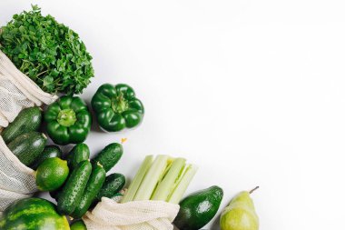 Organik sebzeler ve yeniden kullanılabilir ürün torbalarında taze yeşil. Sürdürülebilir yaşam tarzı. Plastiksiz konsept. Düz yatış, üst görünüm  