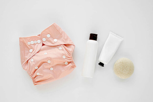 Набор тканевых подгузников и детской косметики. Экологичные тканевые подгузники для новорожденных. Концепция детской гигиены. Плоский, вид сверху
