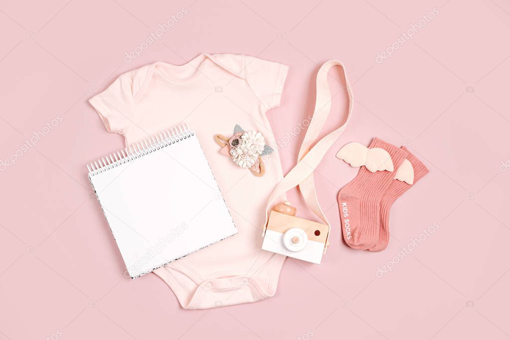 Pale pink cute baby bodysuit with mock up card. Set of kids clothes and accessories. Fashion newborn. Flat lay, top view
