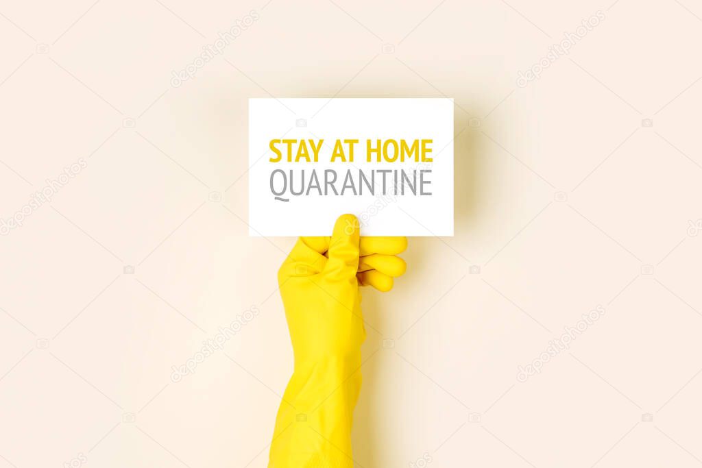 Man in protective gloves holds a warning poster. The epidemic of coronavirus covind-19 2019-ncov. Quarantine, Stay Home, Working From Home.