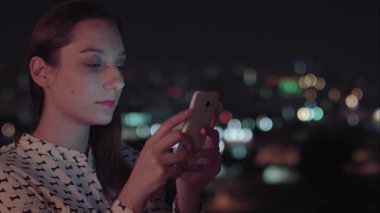 Gece akıllı telefon kullanan Brezilyalı bir kadın.
