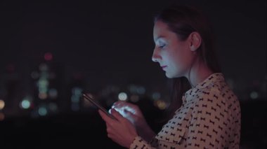 Sao Paulo şehrinde gece tablet kullanan Brezilyalı bir kadın.