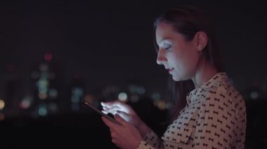 Sao Paulo şehrinde gece tablet kullanan Brezilyalı bir kadın.