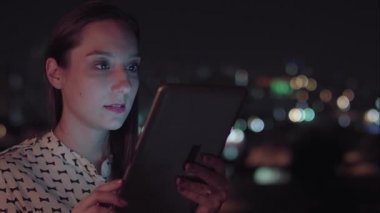 Sao Paulo şehrinde gece tablet kullanan Brezilyalı bir kadın.