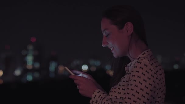 Une femme brésilienne utilisant un smartphone la nuit — Video