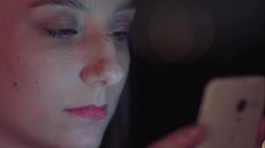 Gece akıllı telefon kullanan Brezilyalı bir kadın.