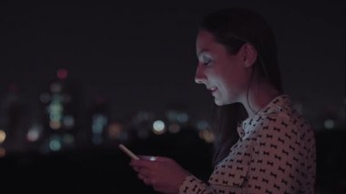 Gece akıllı telefon kullanan Brezilyalı bir kadın.