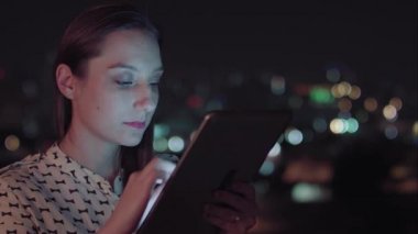Sao Paulo şehrinde gece tablet kullanan Brezilyalı bir kadın.