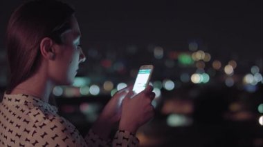 Gece akıllı telefon kullanan Brezilyalı bir kadın.