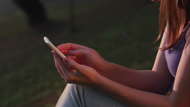 Une femme brésilienne utilisant un smartphone au coucher du soleil du parc à So Paulo — Video