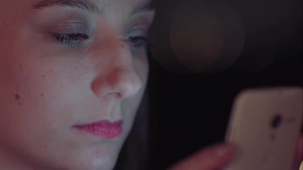 Una mujer brasileña usando smartphone por la noche — Vídeos de Stock