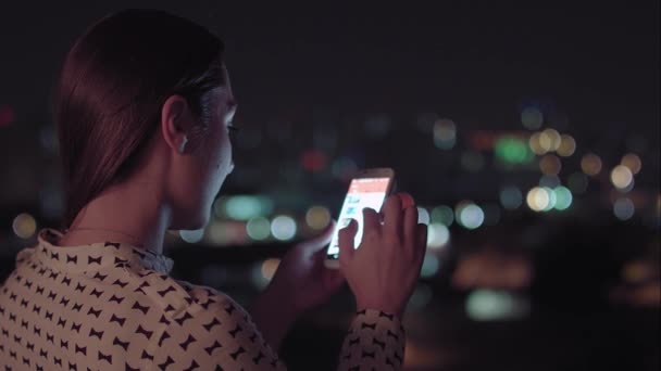Eine Brasilianerin nutzt nachts ihr Smartphone — Stockvideo