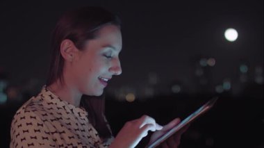 Sao Paulo şehrinde gece tablet kullanan Brezilyalı bir kadın.