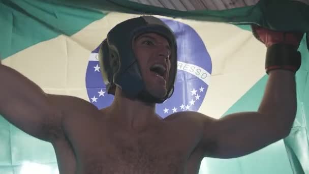 Un boxeador brasileño celebra su victoria con la bandera brasileña — Vídeo de stock