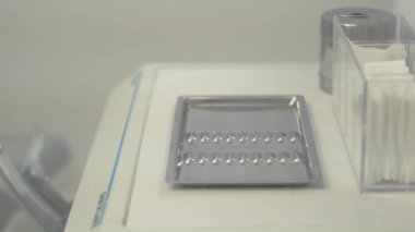 Bir dişçi ekipmanlarını paslanmaz çelik tepsiyle düzenler.