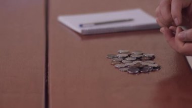 Orta yaşlı Brezilyalı bir adam evin faturalarını ödemek için para sayıyor.