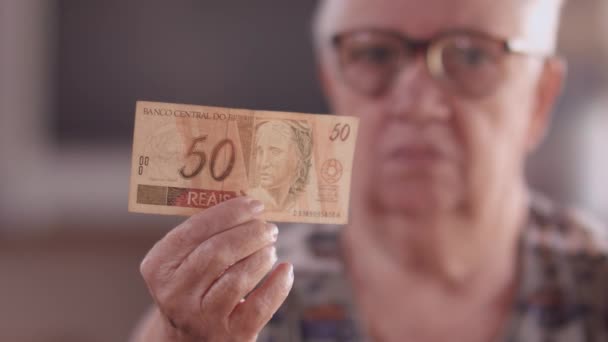 Eine Ältere Brasilianische Dame Zeigt Einen Schein Von Reais — Stockvideo
