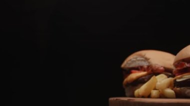 Domatesli hamburger, pastırma, peynir, sos ve patates kızartması.