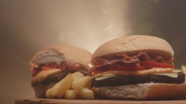 Domatesli hamburger, pastırma, peynir, sos ve patates kızartması.