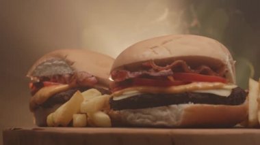 Domatesli hamburger, pastırma, peynir, sos ve patates kızartması.