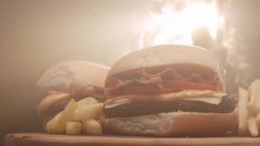 Domatesli hamburger, pastırma, peynir, sos ve patates kızartması.