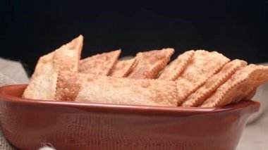 Çamur kabında farklı tatlarda kızartılmış hamur işi.