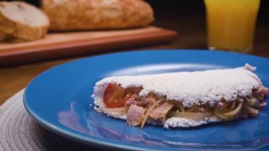 Tipik bir Brezilya yemeği, Tapioca. Yanı sıra Portekizce yazılmış: Tapioca