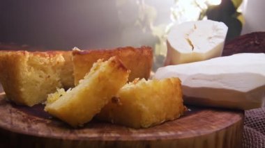 Kesilmiş bir parça Cassava keki ve arka planda manyok.